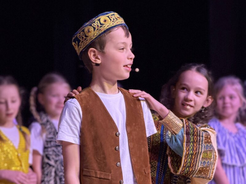 Young pupil dressed as Aladdin performing on stage