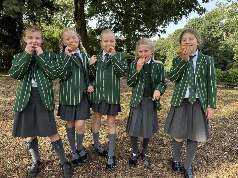 Children in school uniform enjoying pastries
