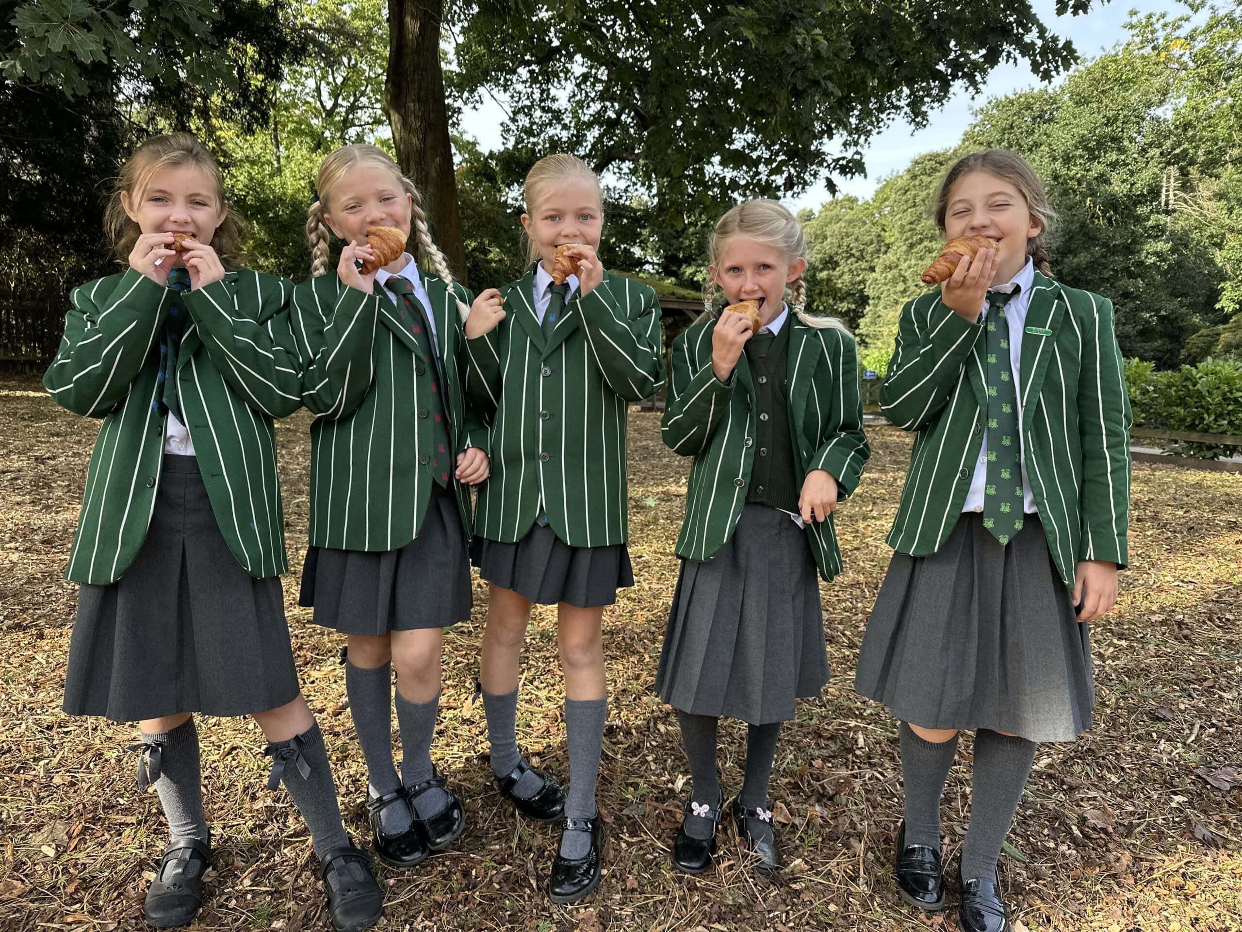 Children in school uniform enjoying pastries