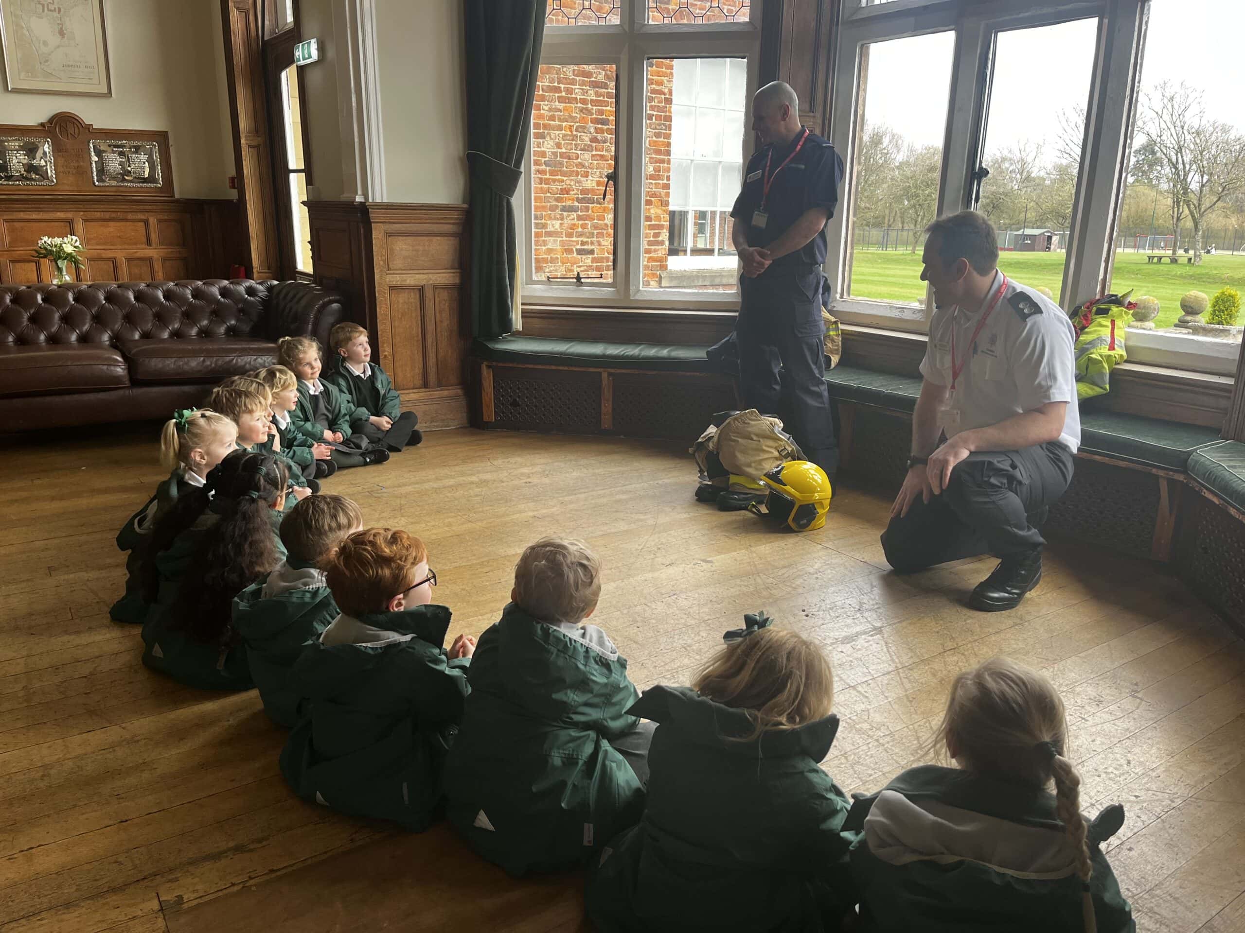 Children listening to a talk from a firefighter