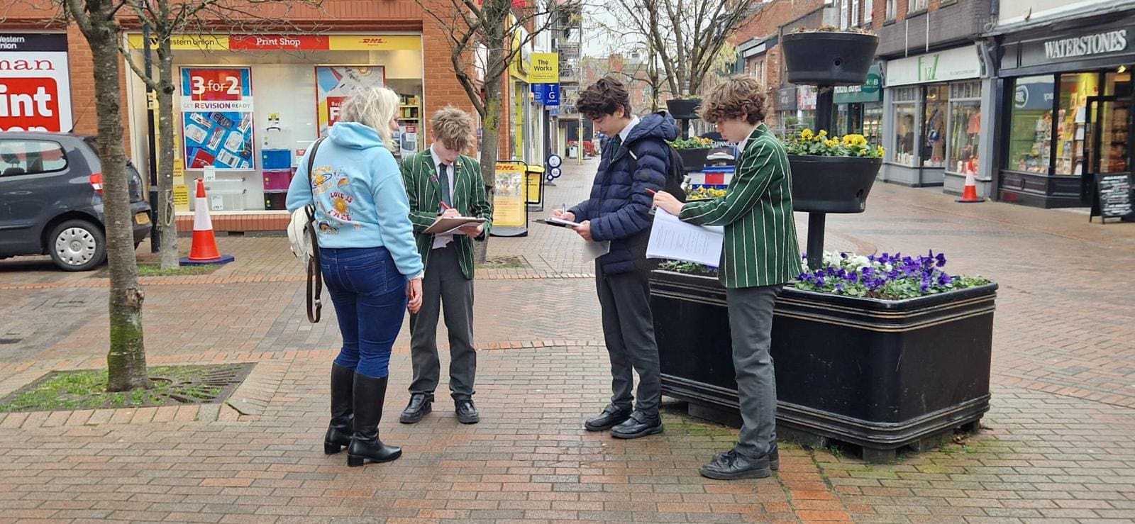 School children carrying out survey with local shoppers