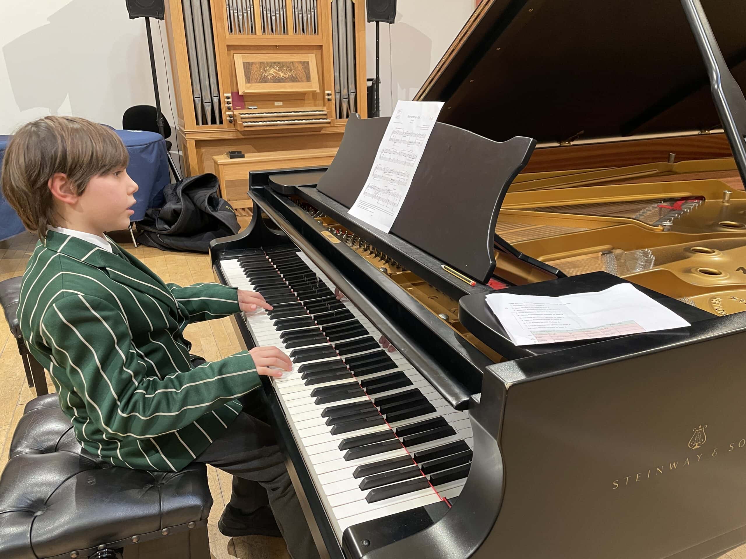 Boy playing Steinway piano