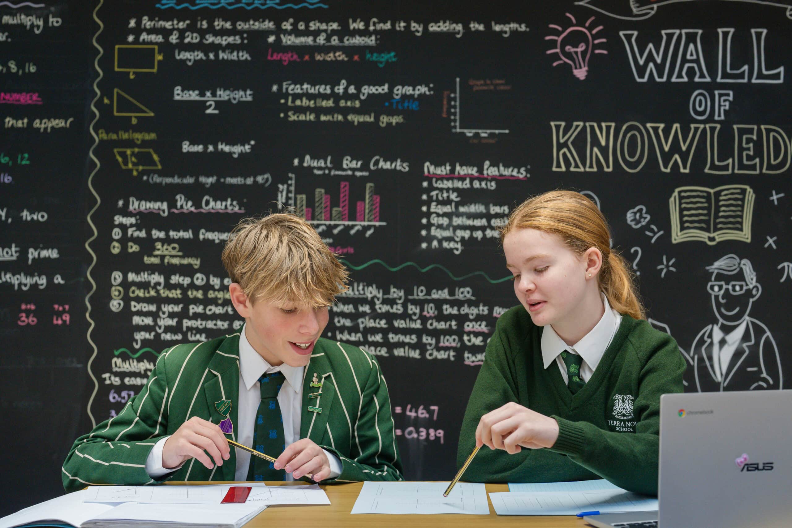 Girl and boy in vibrant Maths classroom, working together.