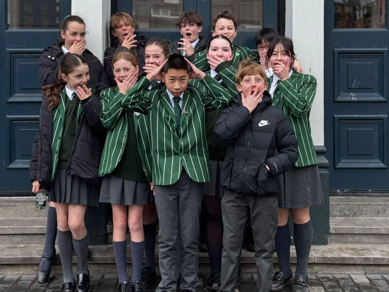 School children outside theatre with surprised expressions