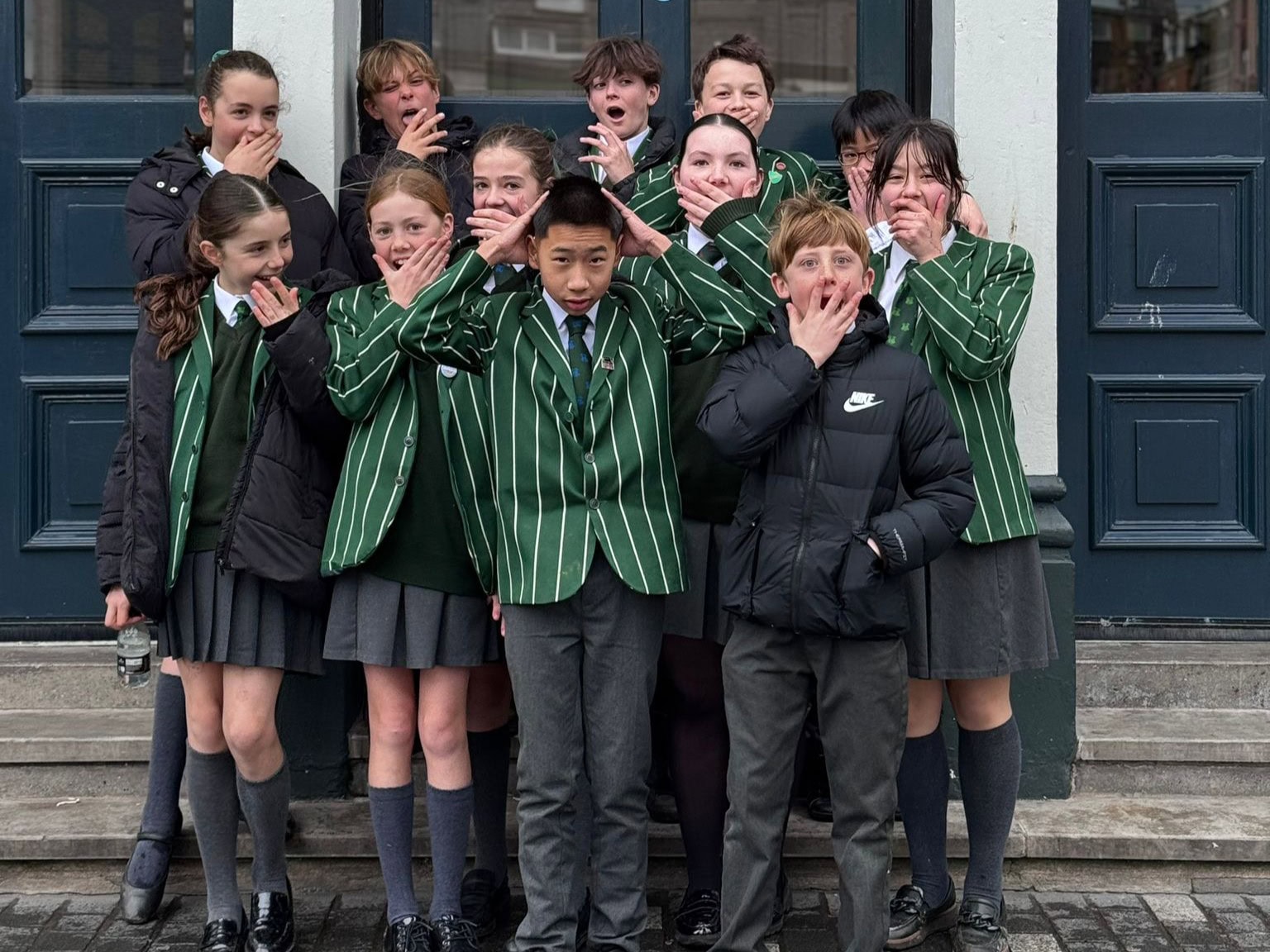 School children outside theatre with surprised expressions